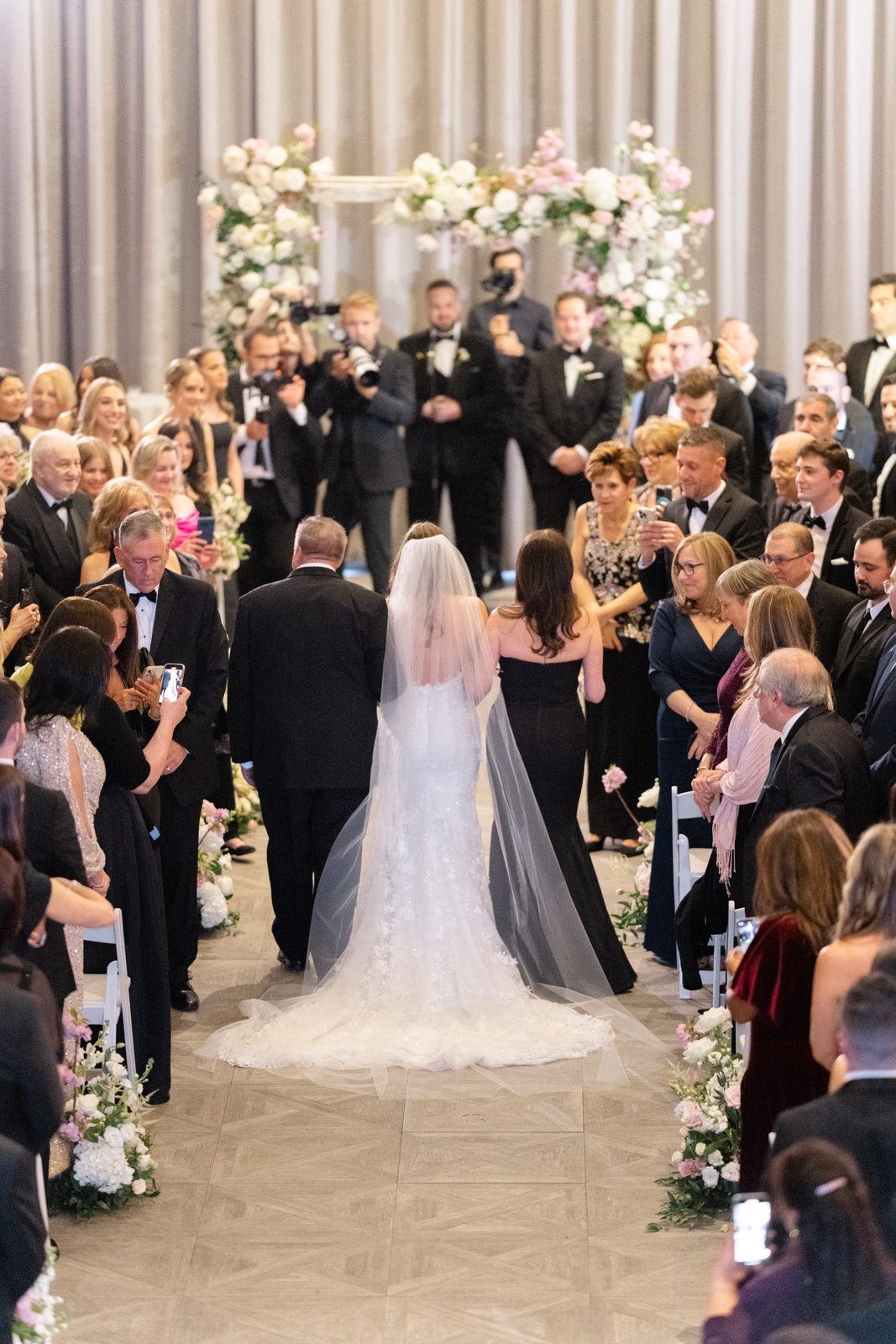 Amanda walking down the aisle toward the floral arch