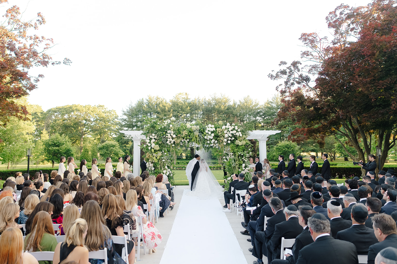 Rebecca and Phil’s outdoor wedding ceremony under a greenery-wrapped chuppah