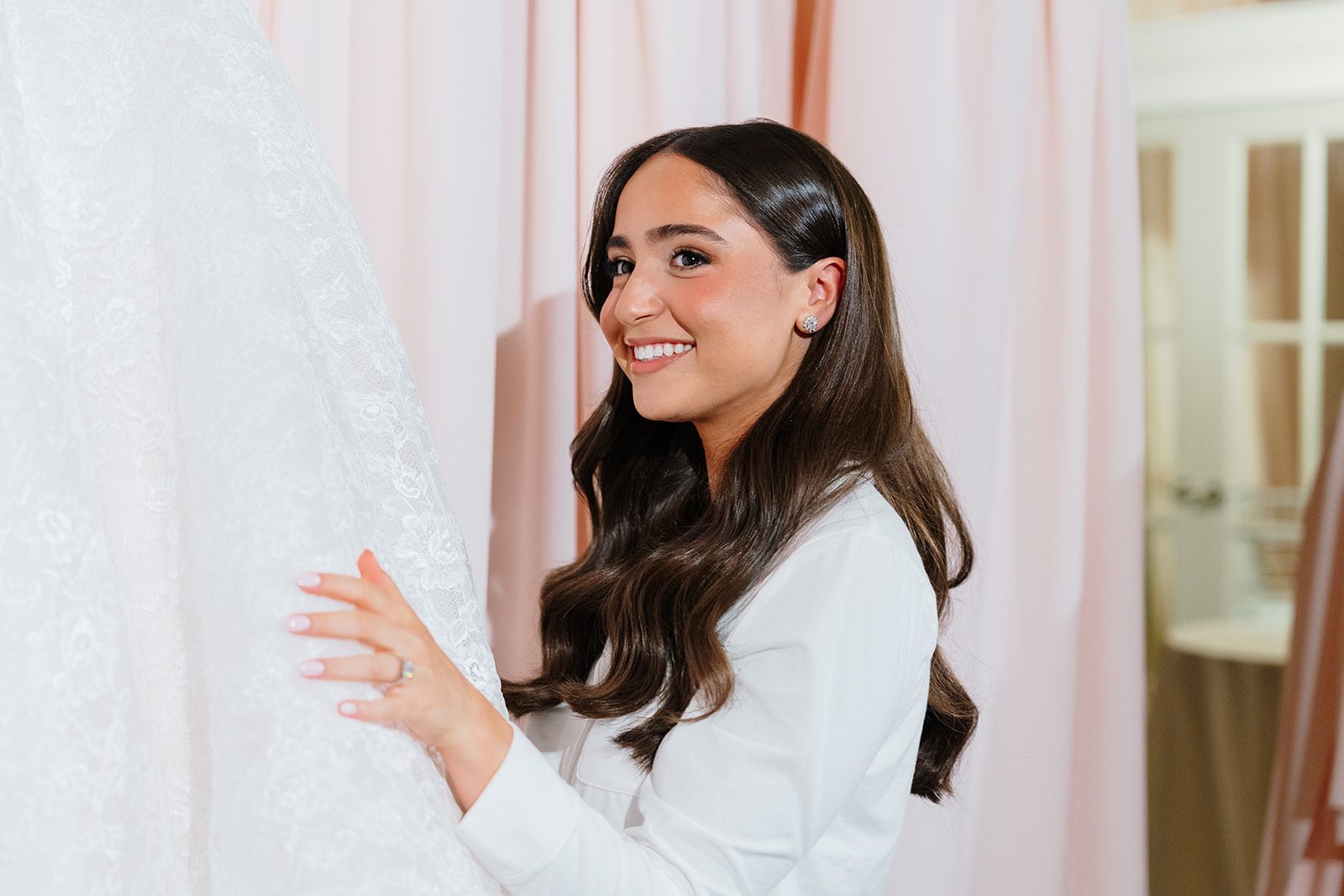 Rosalie smiling beside her gown while getting ready at Edgewood Country Club