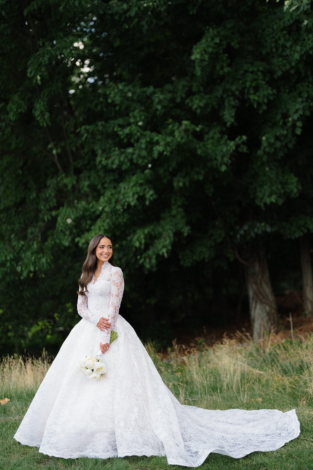 Bride in a long-sleeve lace Anna Augusta ballgown on the grounds of Edgewood Country Club