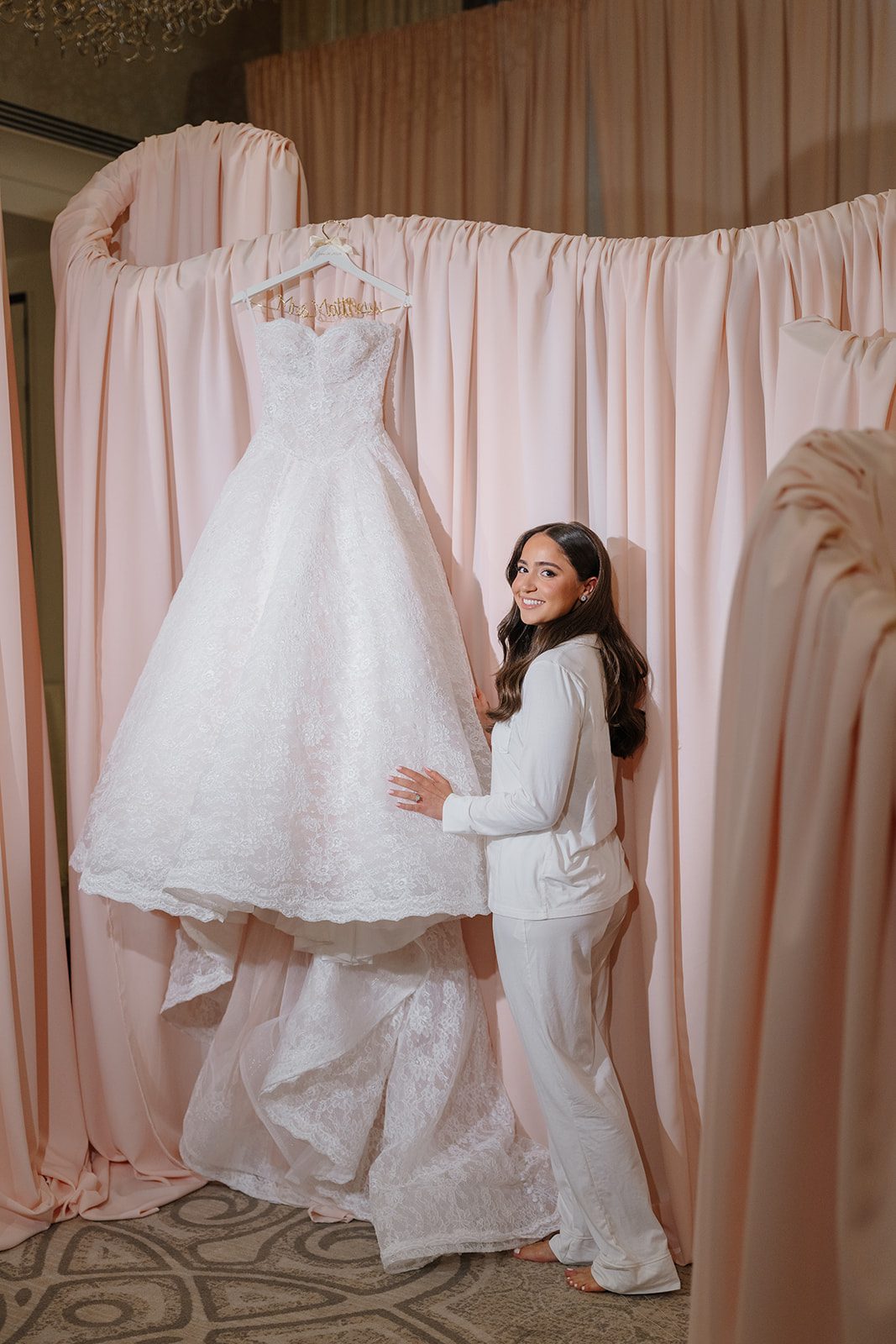 Bride admiring her Anna Augusta ballgown hanging at Edgewood Country Club