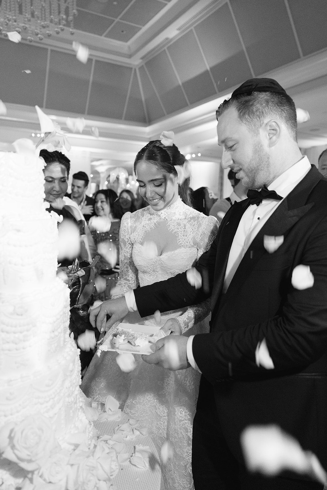 Cake cutting with falling petals in black and white