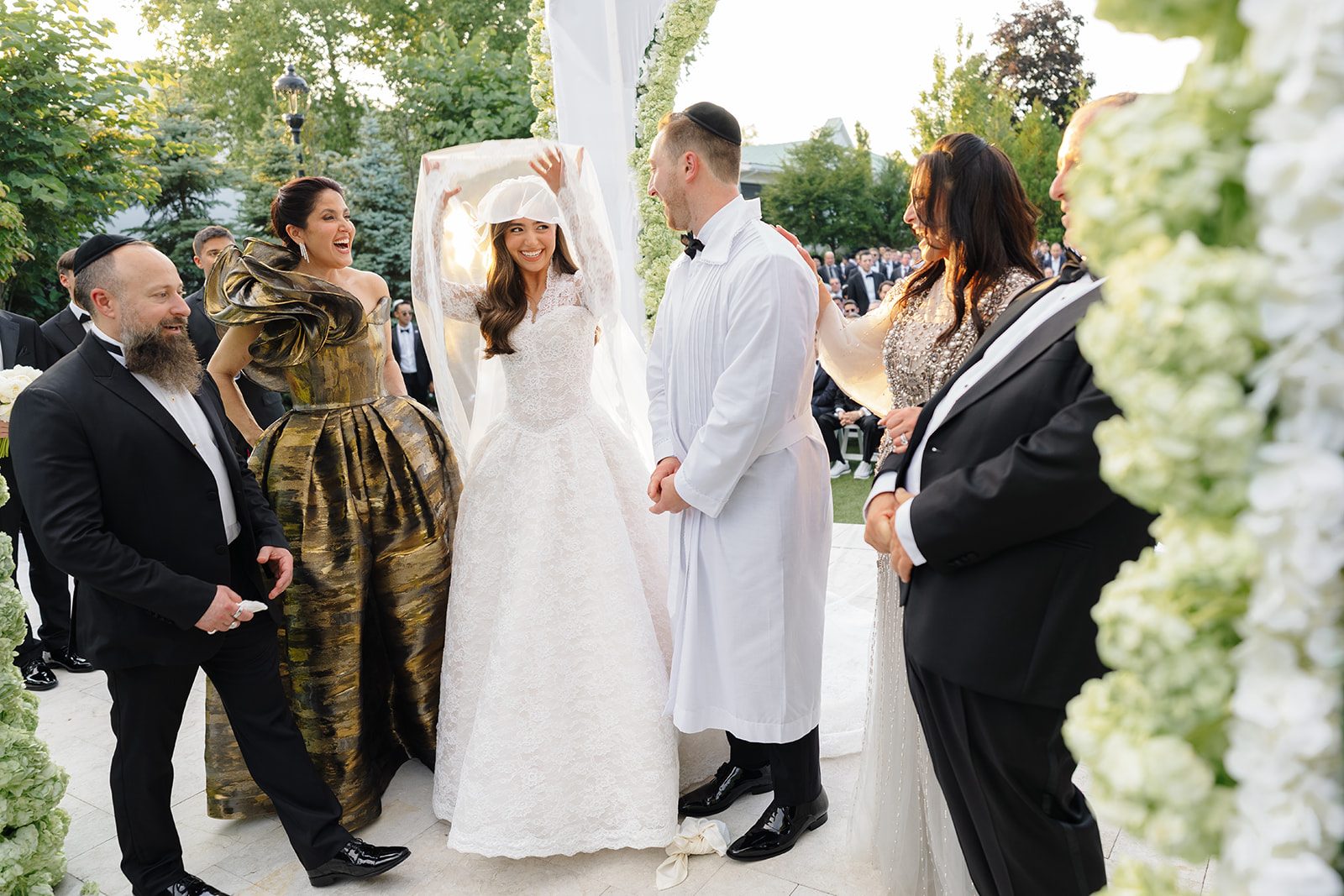 Rosalie raises her arms in celebration under the chuppah