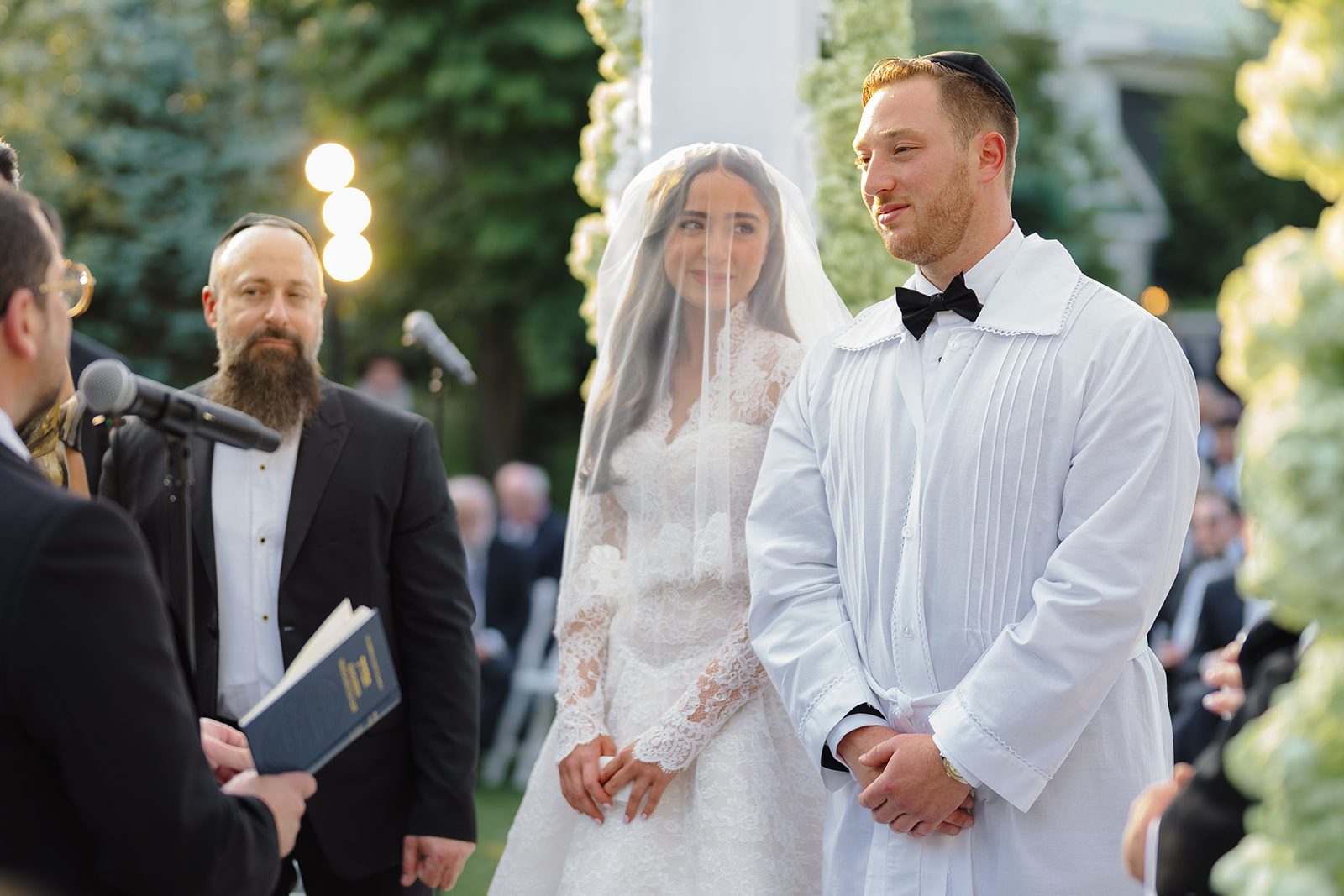 Rosalie and Josh under the greenery chuppah during the ceremony at Edgewood Country Club