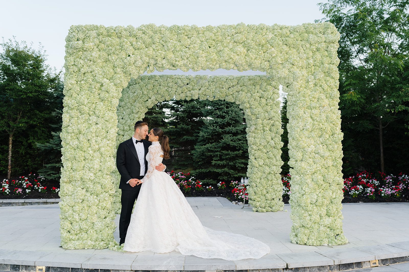 Rosalie and Josh beneath the white and green chuppah at Edgewood Country Club