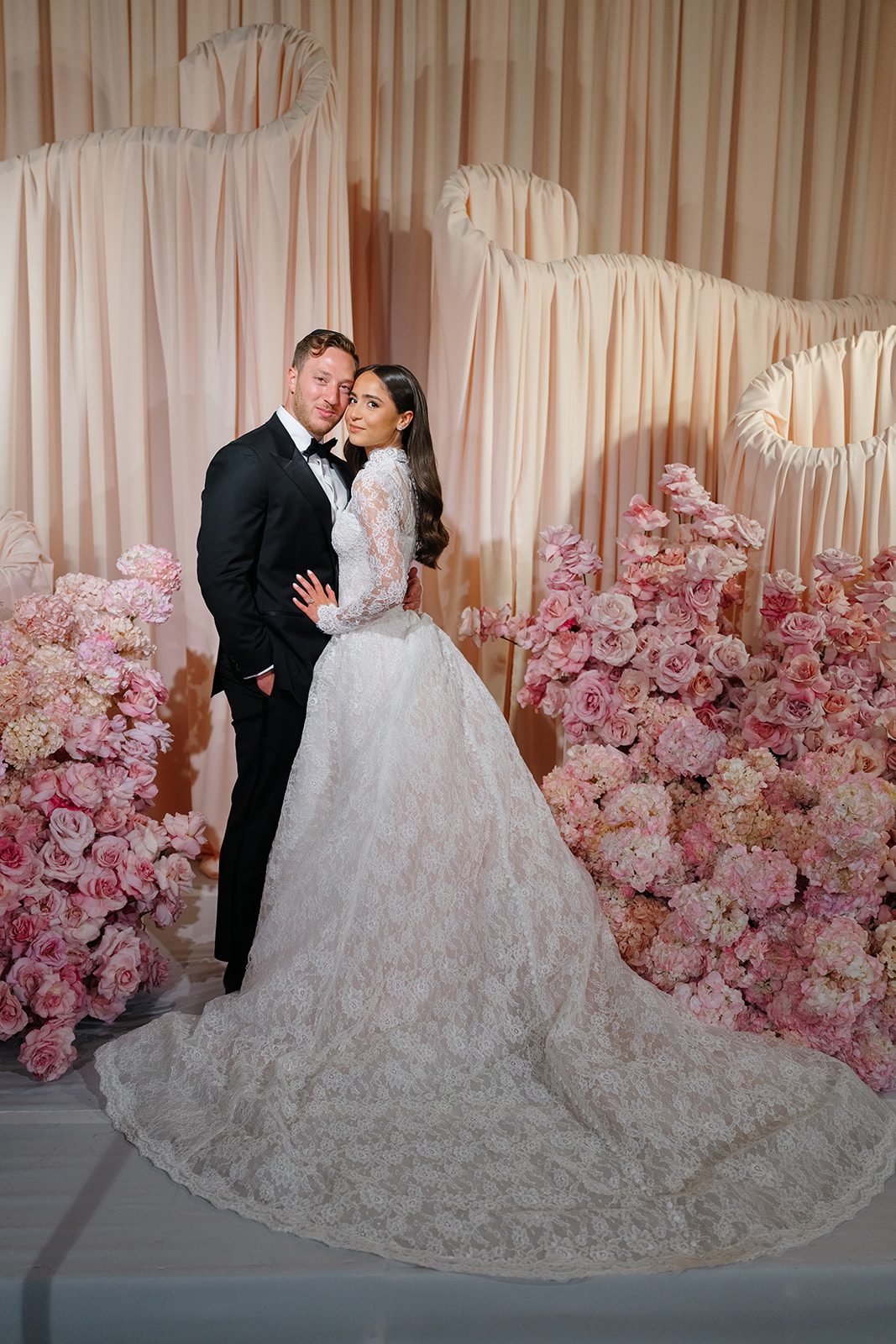 Bride and groom beside cascading pink roses at Edgewood Country Club in New Jersey