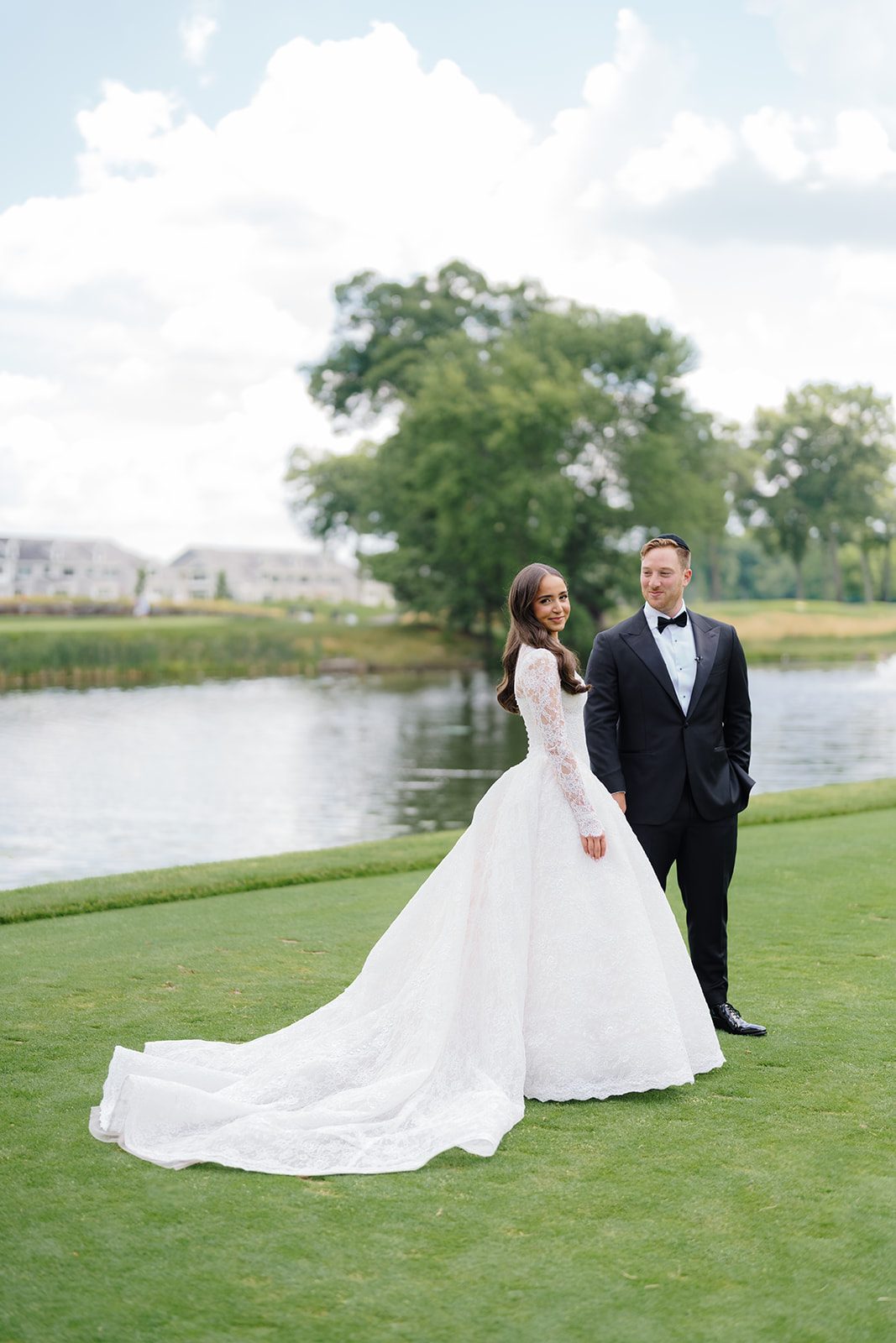 Bride and groom beside the lake on the golf course at Edgewood Country Club