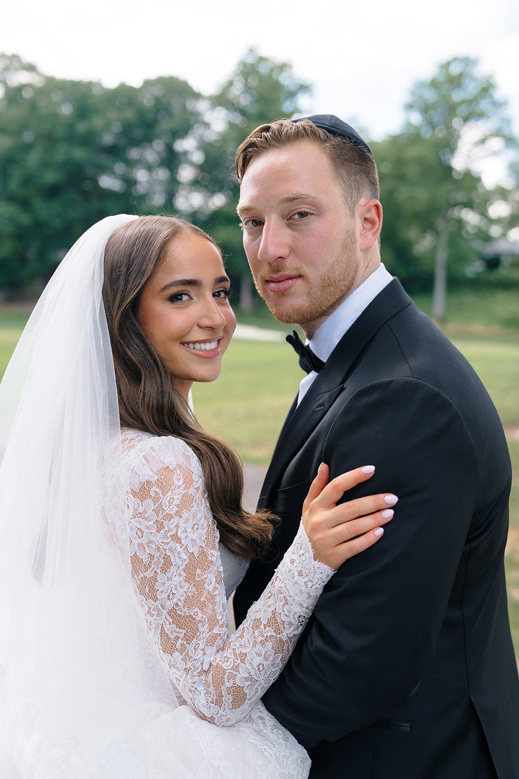 Bride and groom smiling under her cathedral veil at Edgewood Country Club