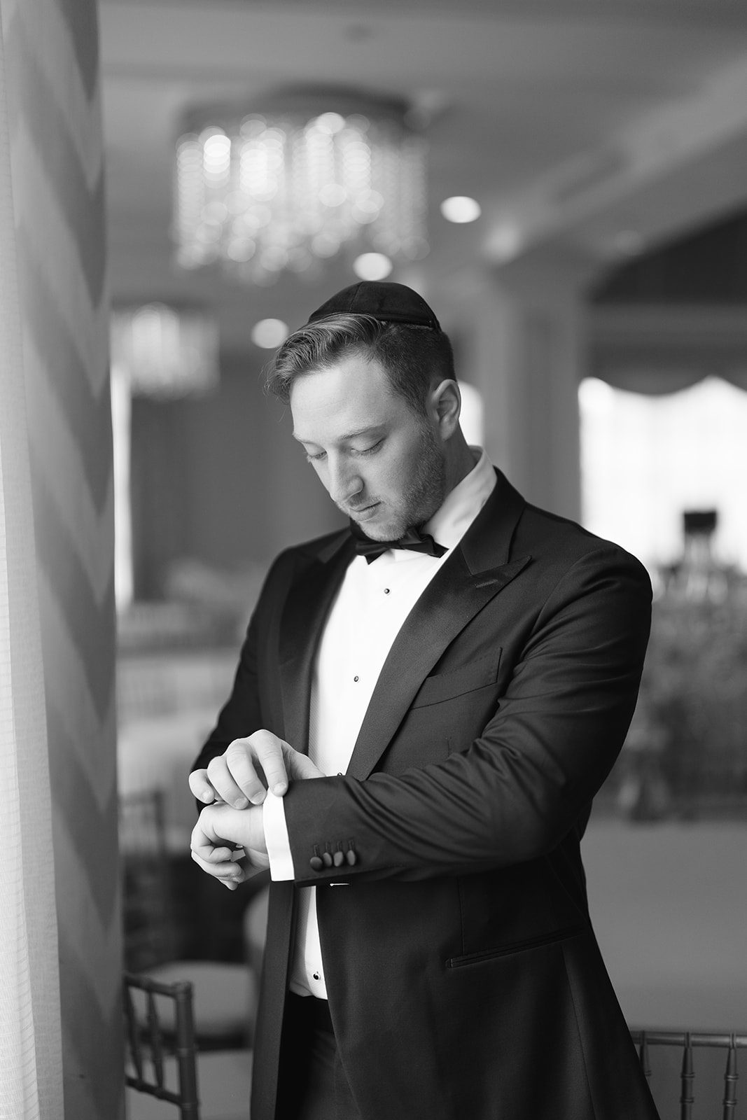 Groom checking his watch in black and white before the first look at Edgewood Country Club