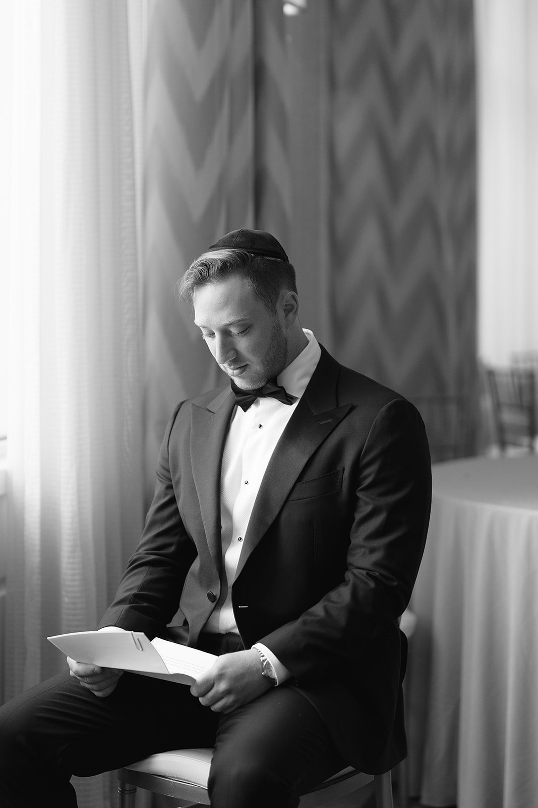 Groom reading a handwritten letter from his bride, black and white