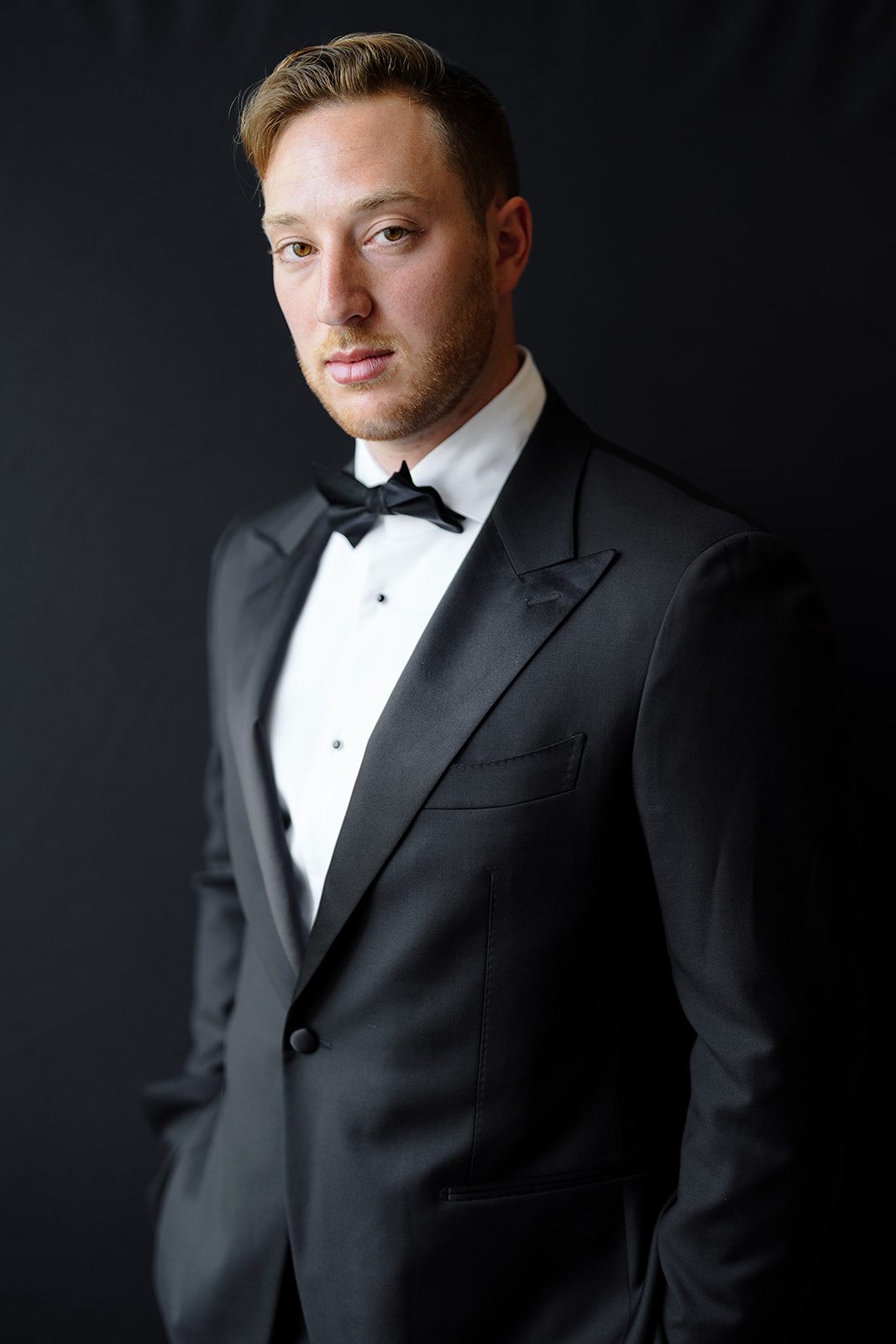 Groom portrait in a black tuxedo at Edgewood Country Club