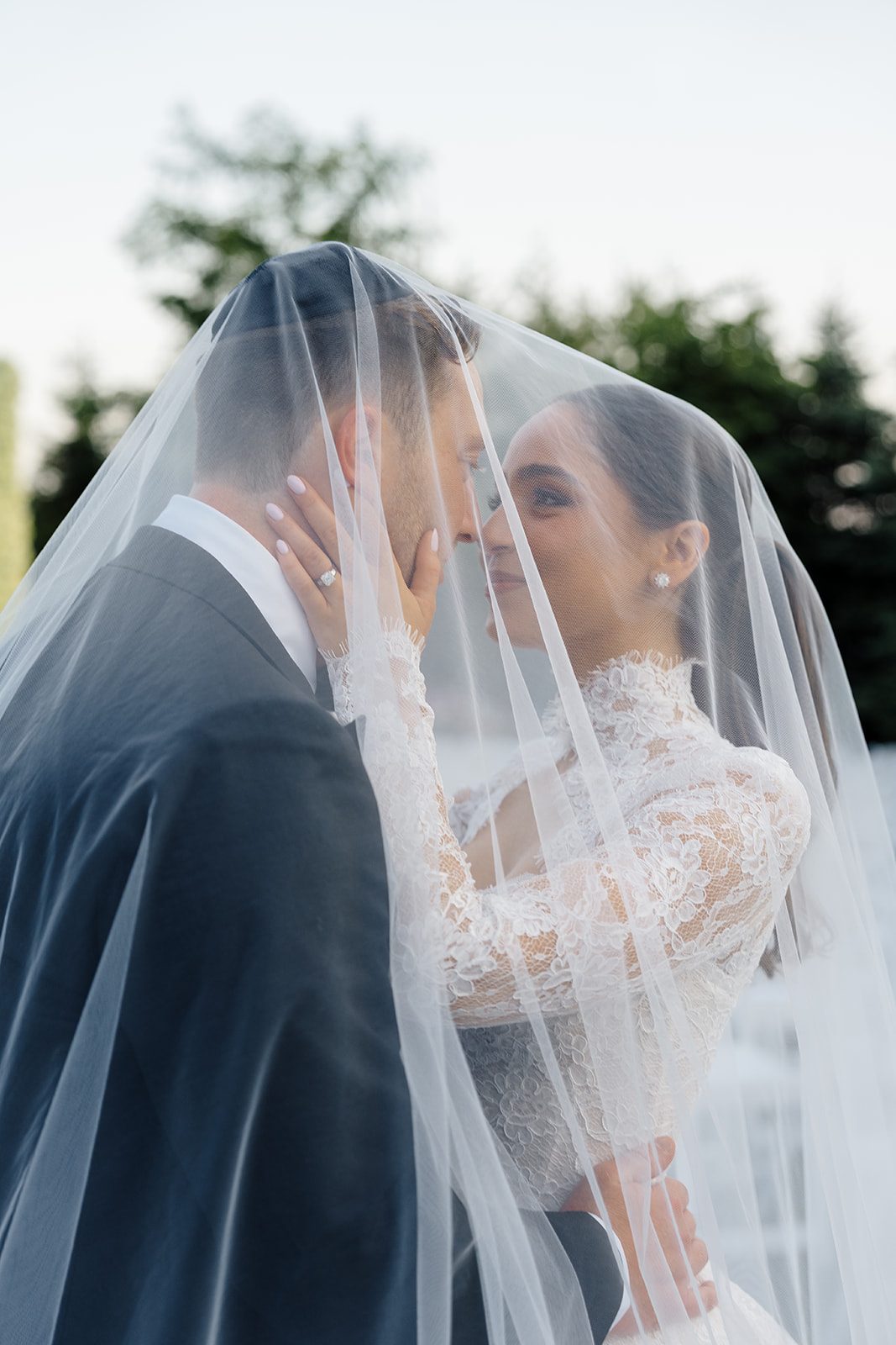 Rosalie and Josh kissing beneath her veil at Edgewood Country Club