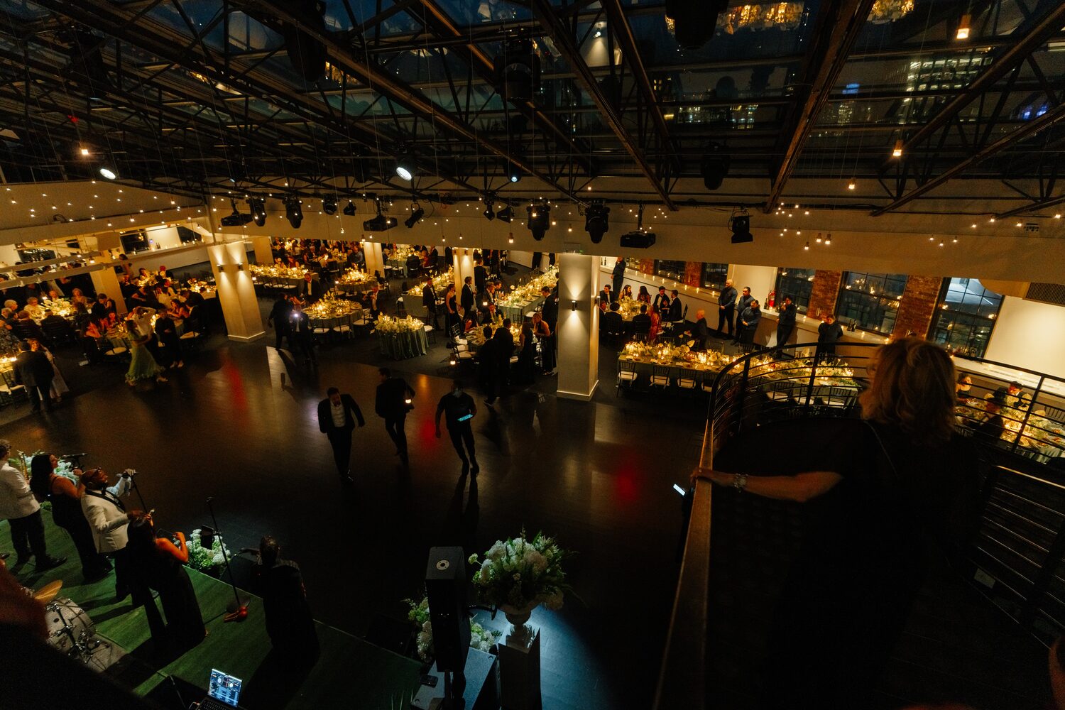 The reception in full swing, warm light spilling across the long tables.