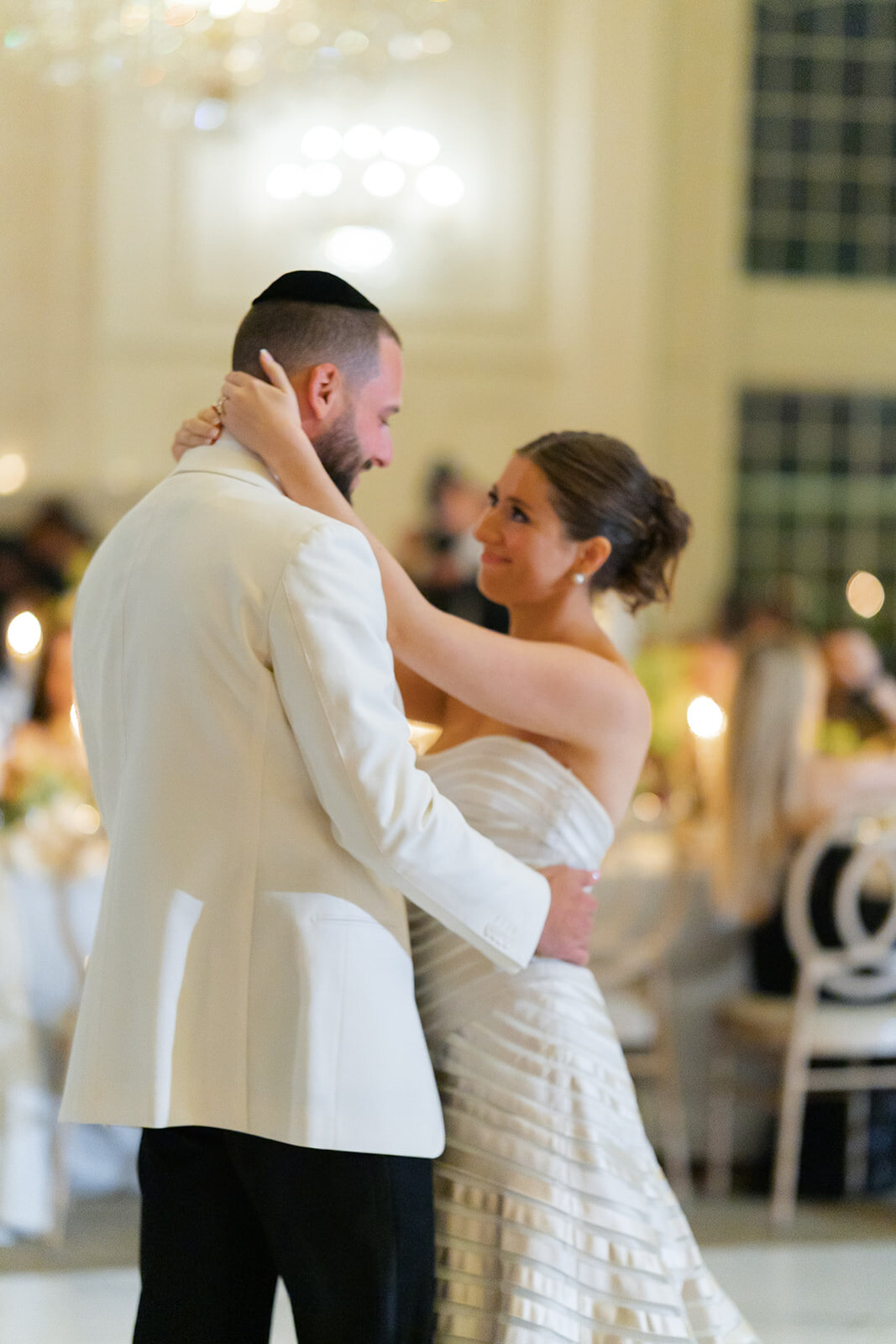 Yarden and Joel share their first dance in the white ballroom
