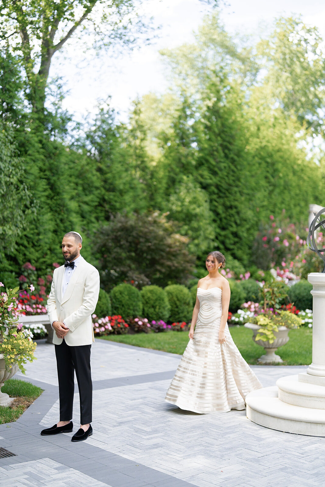 Yarden walks toward Joel on the garden path for their first look at The Estate at Florentine Gardens