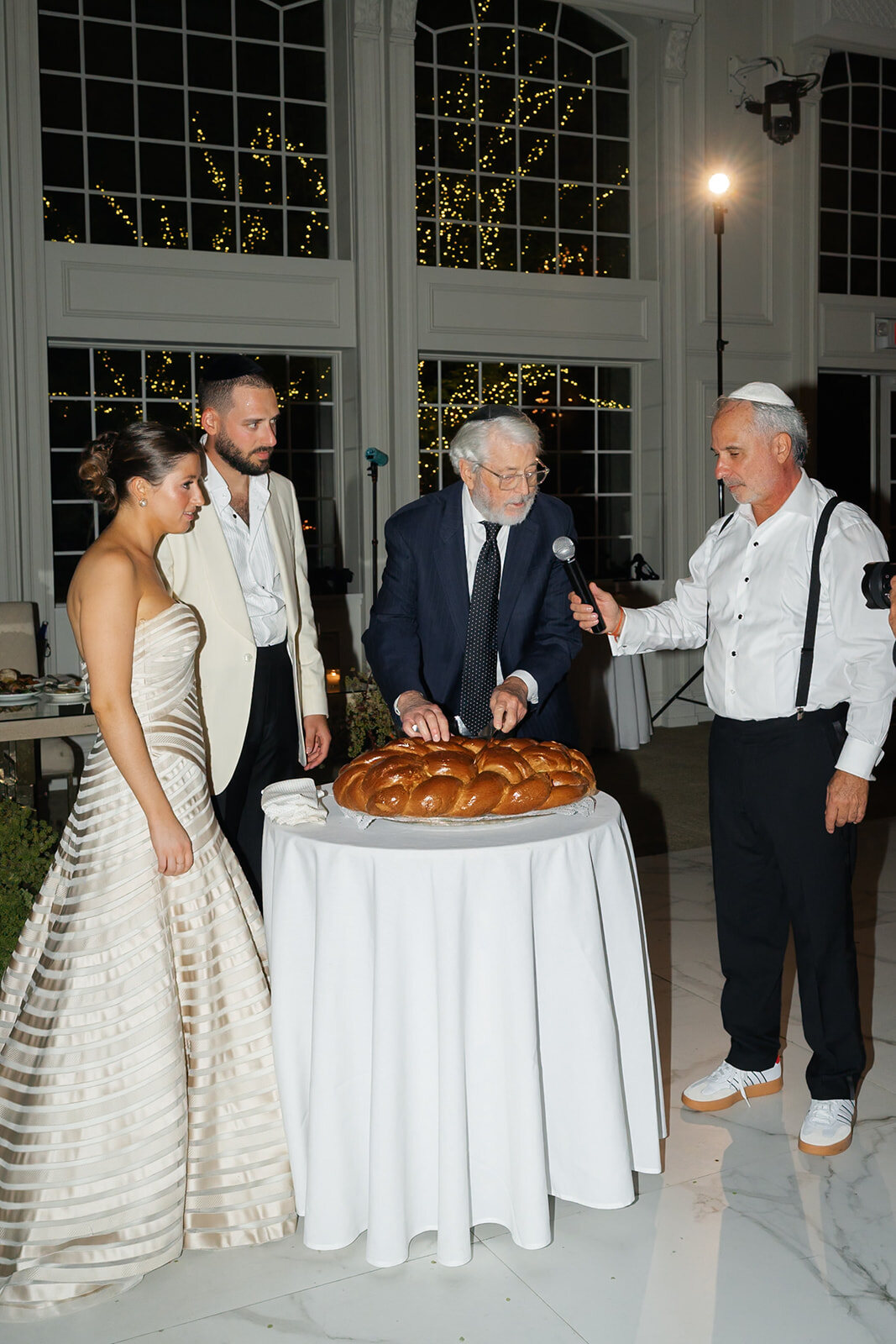 The hamotzi, as the challah is cut beside Yarden and Joel