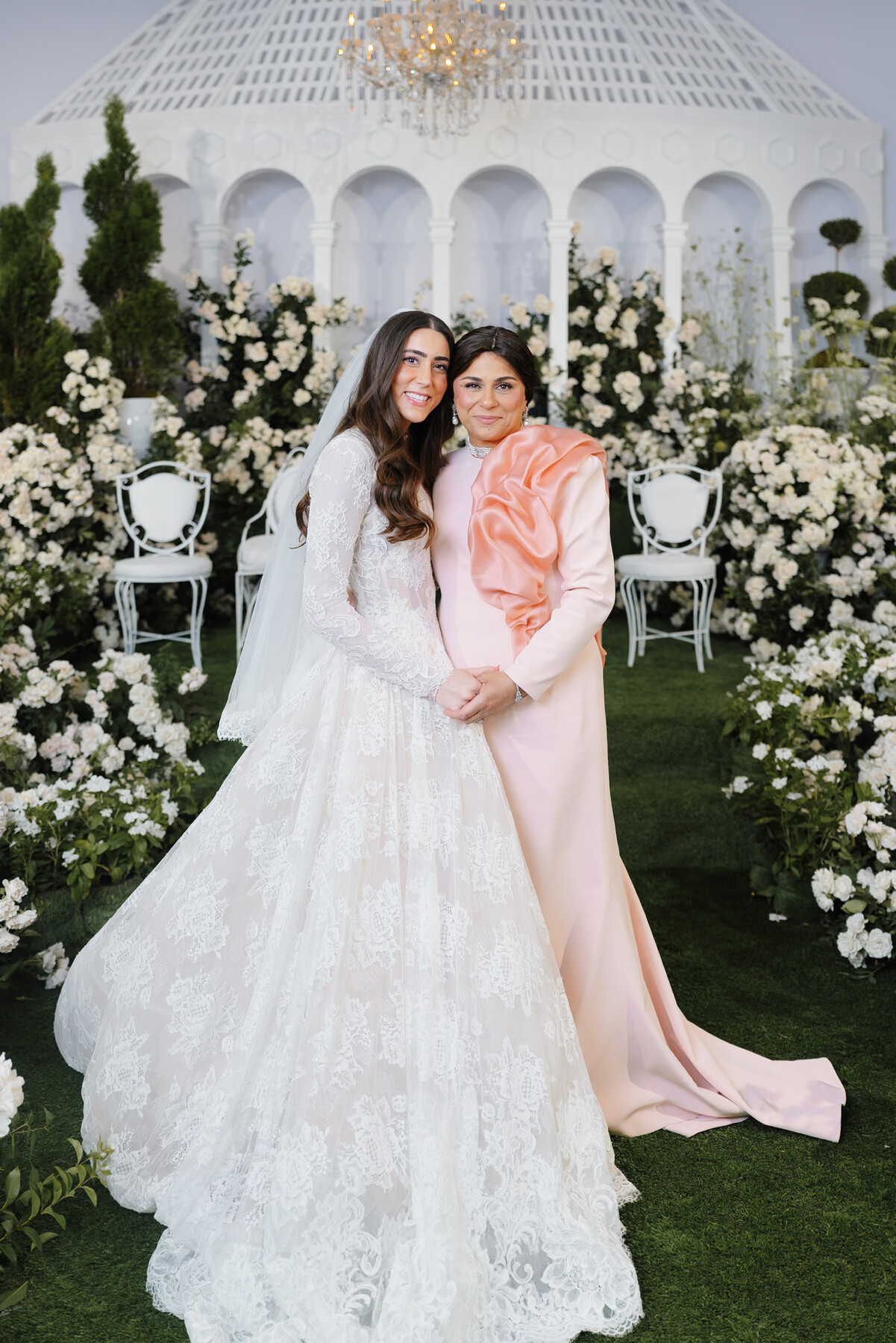 The bride with her mother in front of the white roses, original grade