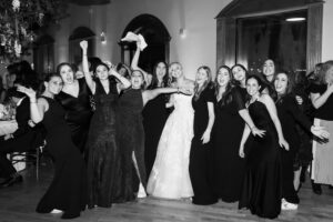Bride and friends celebrate on the dance floor, black and white