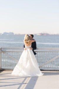 Couple kiss at the waterfront railing on the Liberty Warehouse pier
