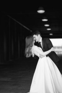 Dip kiss in a warehouse corridor, black and white, Brooklyn wedding