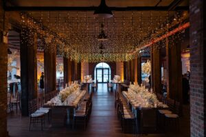 Fairy light canopy over long reception tables inside the Liberty Warehouse, Brooklyn
