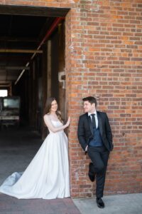 Bride and groom share a first look against the exposed brick of the Liberty Warehouse in Red Hook, Brooklyn