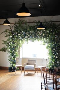Greenery chuppah with blue and white florals inside the Liberty Warehouse