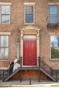 Bride and groom on the steps of the red door at Old Fulton Street, DUMBO, Brooklyn