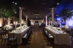 Long reception tables under string lights at the Liberty Warehouse