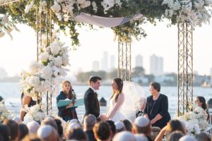Sunset chuppah ceremony on the Liberty Warehouse waterfront deck with the Manhattan skyline behind