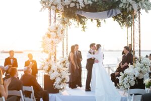 First kiss beneath the chuppah at sunset over the Brooklyn waterfront