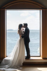 Couple kiss silhouetted in a Liberty Warehouse window overlooking New York Harbor